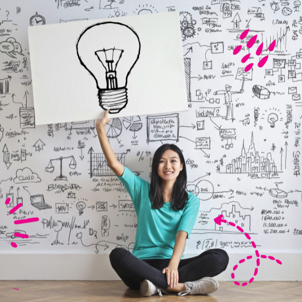 Photo of a young woman holding a white paper with a lightbulb on it