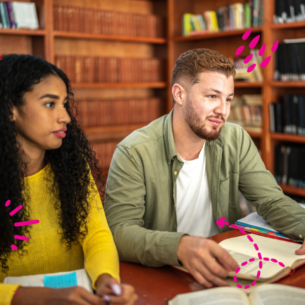 Two students in a library studying