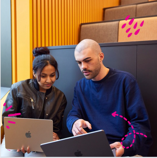 Two students looking at their laptops.